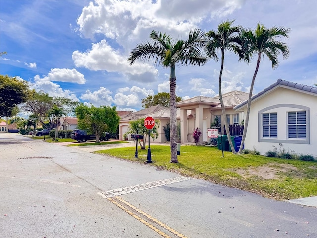 8196 SW 163rd Ct, Miami, FL 33193 - view of front facade featuring stucco siding, a front yard, a garage, driveway, and a tiled roof