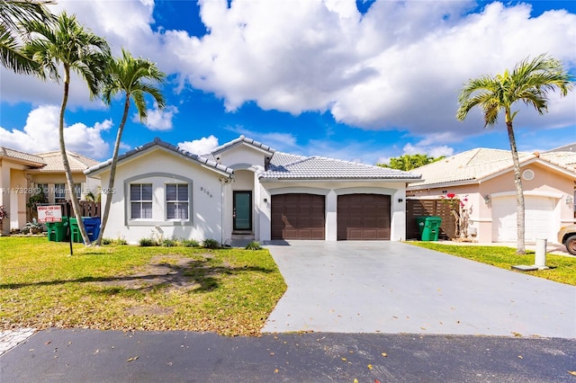 view of front facade with a garage, a tile roof, driveway, stucco siding, and a front yard