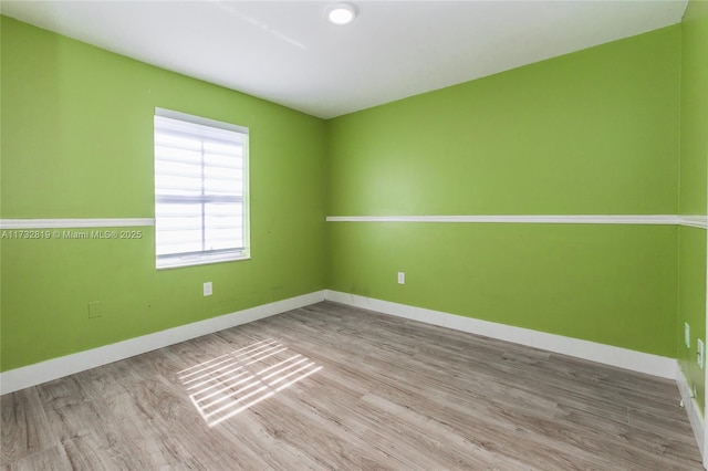 unfurnished room with light wood-style floors and baseboards