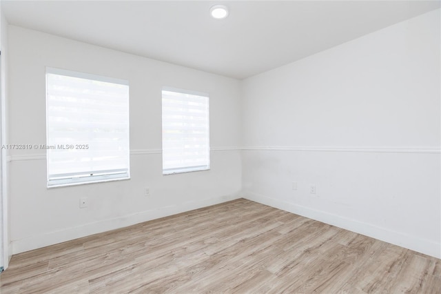 spare room with light wood finished floors and baseboards