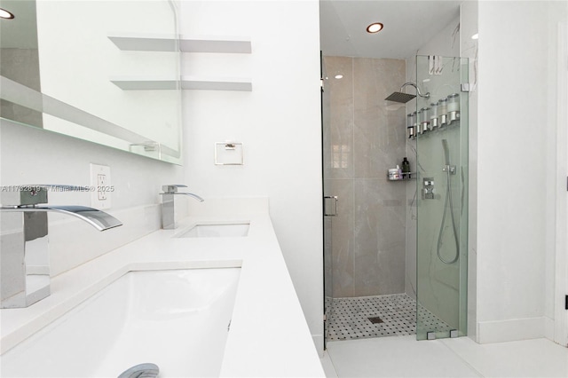 full bath featuring a stall shower, a sink, recessed lighting, and double vanity