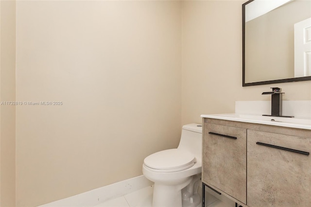 bathroom with tile patterned flooring, vanity, and toilet