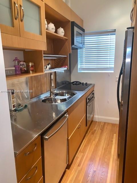 kitchen featuring sink, light hardwood / wood-style flooring, and appliances with stainless steel finishes