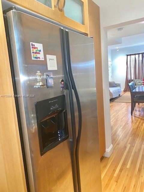 kitchen with hardwood / wood-style flooring and stainless steel fridge