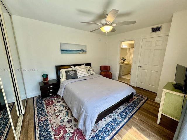 bedroom with ceiling fan, wood-type flooring, ensuite bathroom, and a closet