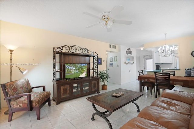 living room featuring ceiling fan with notable chandelier and light tile patterned floors