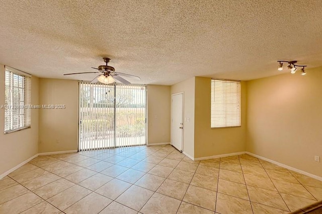 empty room featuring ceiling fan, a textured ceiling, and light tile patterned floors