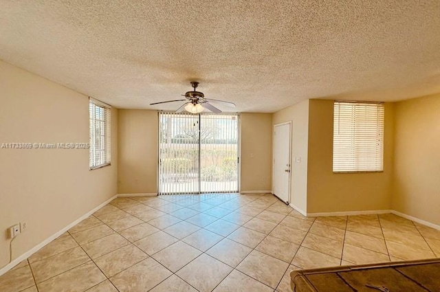 tiled spare room featuring a textured ceiling and ceiling fan