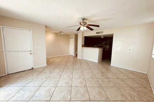 tiled spare room with a textured ceiling and ceiling fan