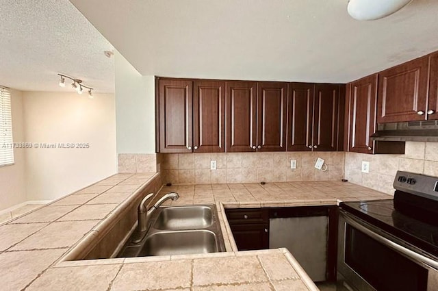 kitchen featuring sink, tasteful backsplash, a textured ceiling, tile countertops, and stainless steel range with electric cooktop