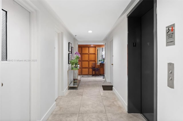 hallway featuring light tile patterned flooring and elevator