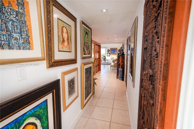 hallway featuring a textured ceiling and light tile patterned flooring