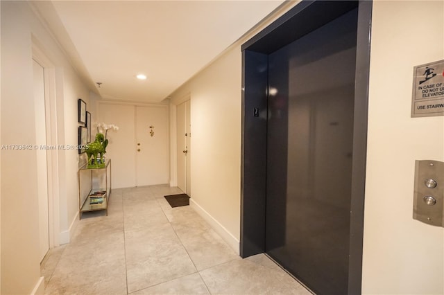 corridor with light tile patterned floors and elevator