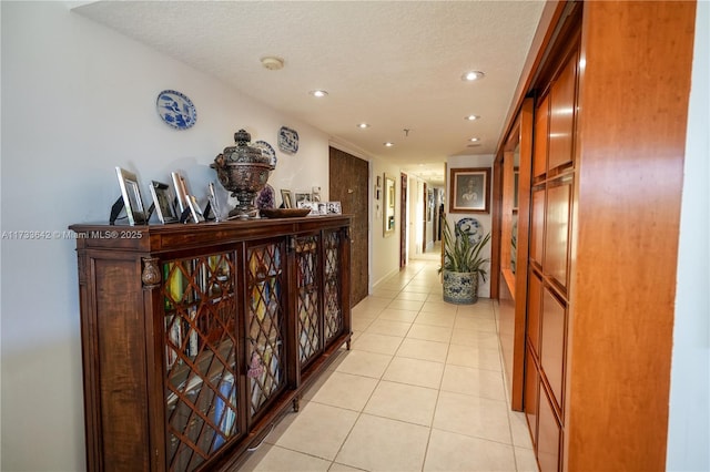 hallway featuring light tile patterned floors and a textured ceiling