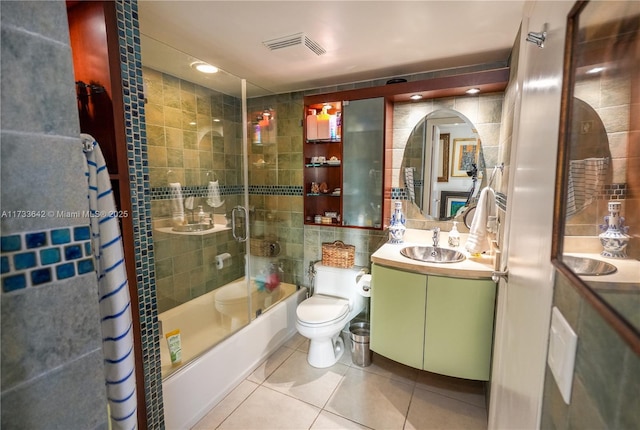 full bathroom with vanity, tile patterned flooring, combined bath / shower with glass door, and tile walls