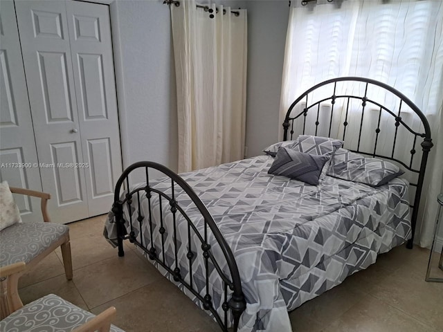 bedroom with tile patterned floors and a closet