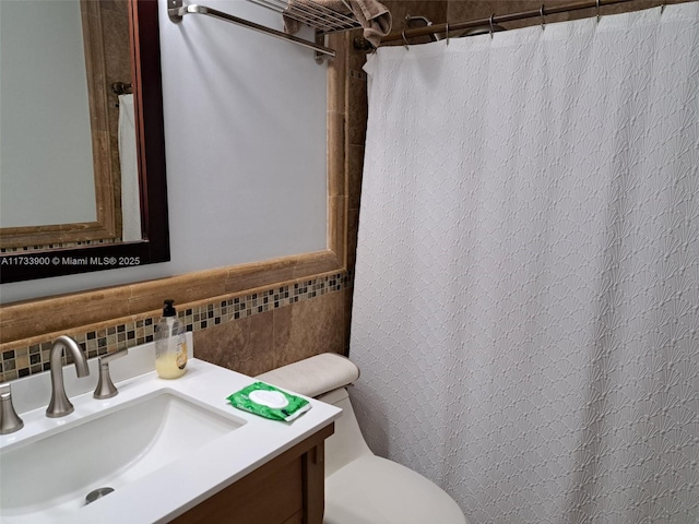 bathroom featuring vanity, backsplash, and toilet