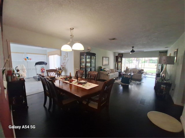 dining area with ceiling fan and a textured ceiling