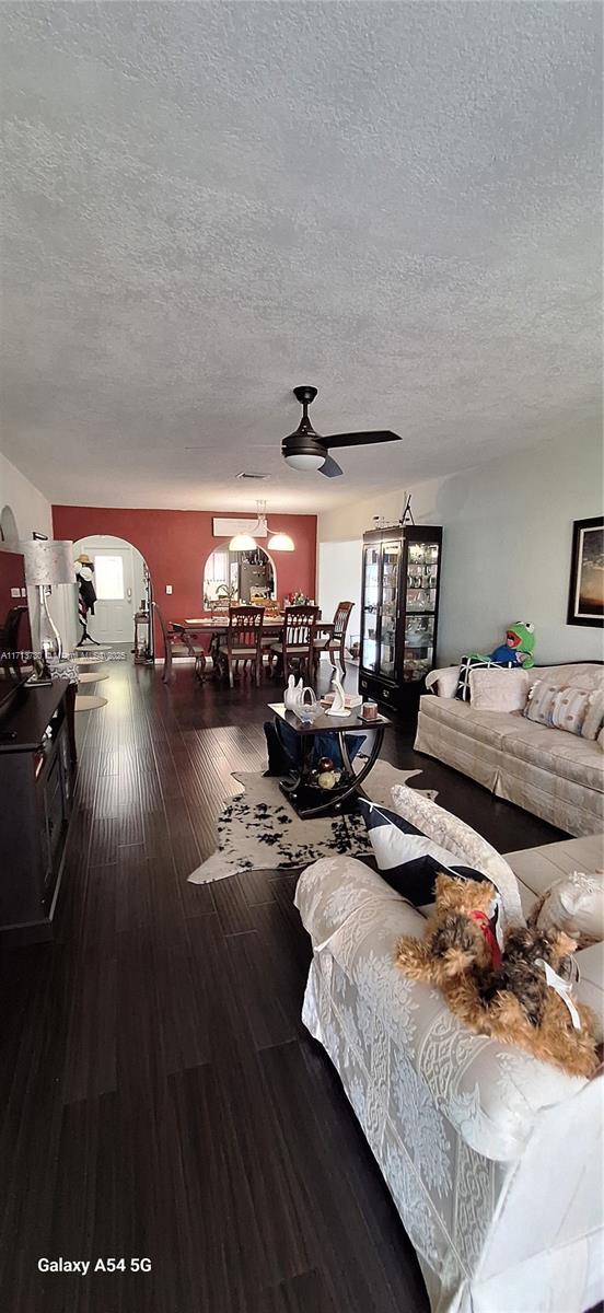 living room with wood-type flooring and a textured ceiling