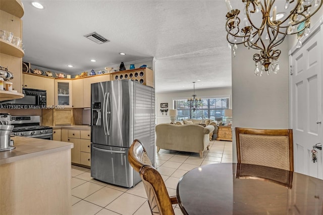 kitchen featuring light tile patterned floors, visible vents, glass insert cabinets, appliances with stainless steel finishes, and a notable chandelier