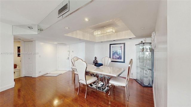 dining area featuring hardwood / wood-style flooring and a raised ceiling