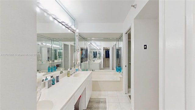 bathroom featuring tile patterned flooring, vanity, and a tub