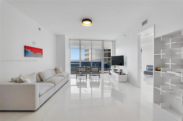 tiled living room featuring floor to ceiling windows