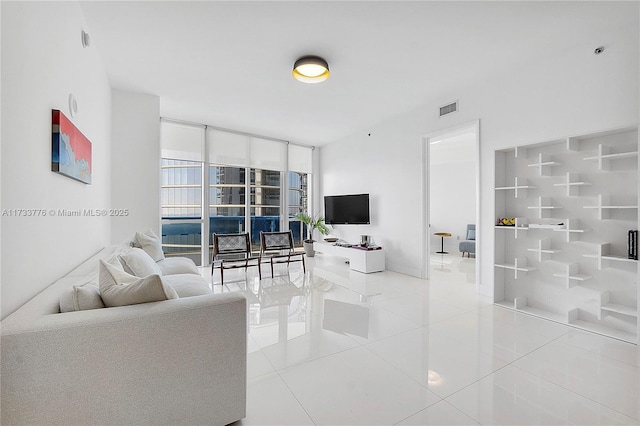 tiled living room featuring a wall of windows