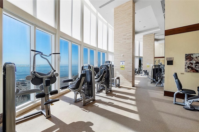 gym with a high ceiling and a water view