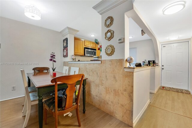 dining area with tile walls and light hardwood / wood-style flooring