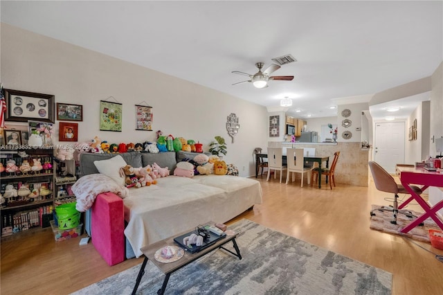 bedroom featuring stainless steel refrigerator, ceiling fan, and light wood-type flooring