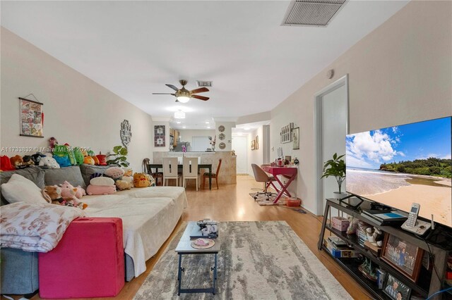 living room featuring ceiling fan and light wood-type flooring