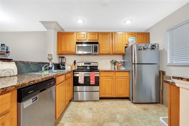 kitchen featuring appliances with stainless steel finishes, stone countertops, and sink