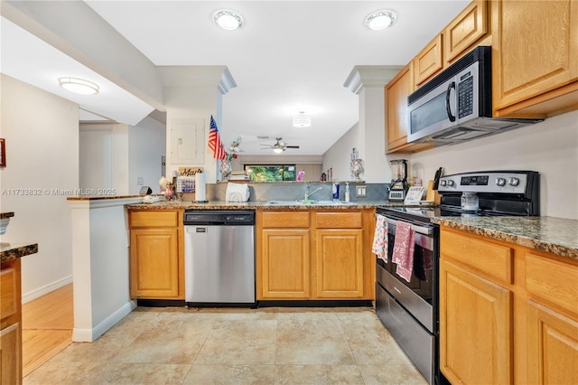 kitchen with sink, ceiling fan, stone counters, stainless steel appliances, and kitchen peninsula