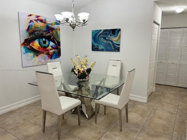 tiled dining space featuring a chandelier and a textured ceiling