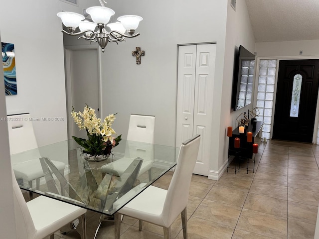 dining area featuring an inviting chandelier, light tile patterned floors, lofted ceiling, and a textured ceiling