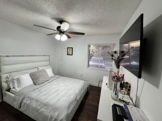 bedroom featuring a textured ceiling, dark wood-type flooring, and ceiling fan