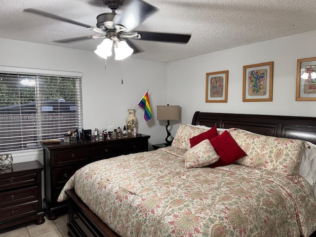 tiled bedroom with ceiling fan and a textured ceiling