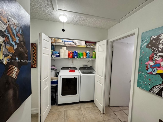 washroom featuring light tile patterned floors, washer and dryer, and a textured ceiling