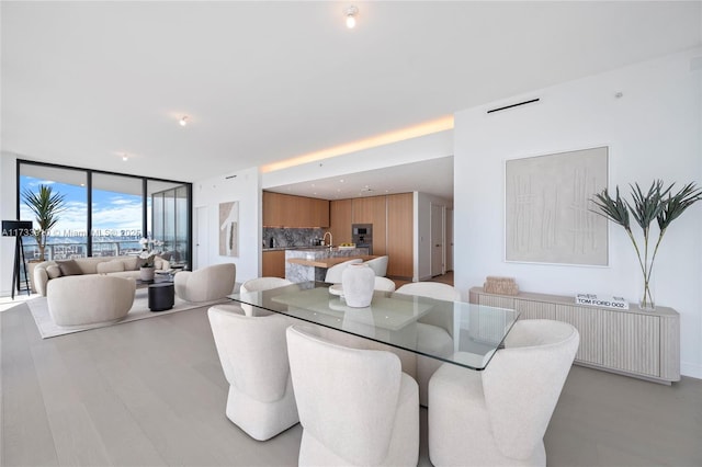 dining area with a wall of windows and light wood-style floors