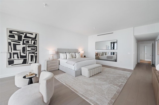 bedroom with baseboards and wood finished floors