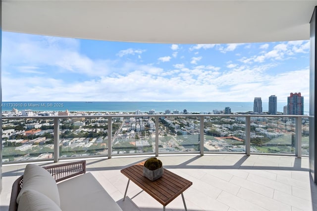 balcony featuring a water view and a city view