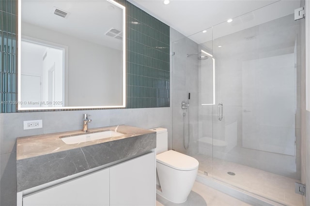 full bath featuring toilet, a stall shower, vanity, and visible vents