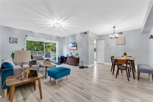 living room with an inviting chandelier and light hardwood / wood-style flooring