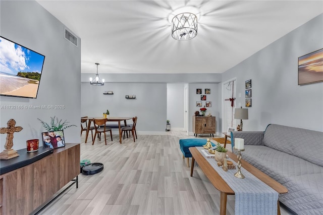 living room with a notable chandelier and light hardwood / wood-style flooring