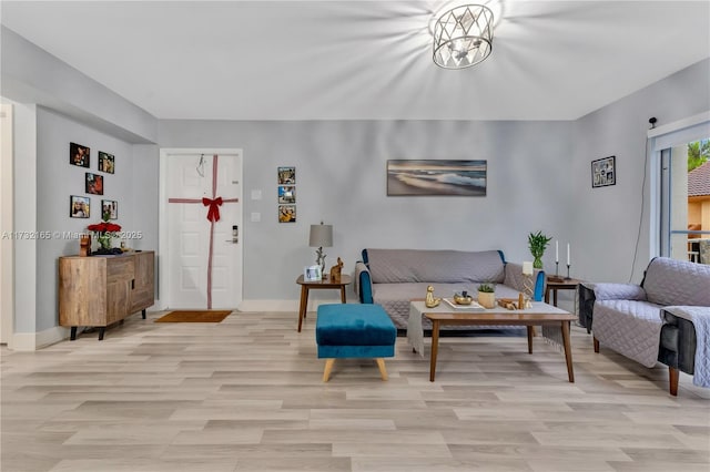 living room with a chandelier and light wood-type flooring