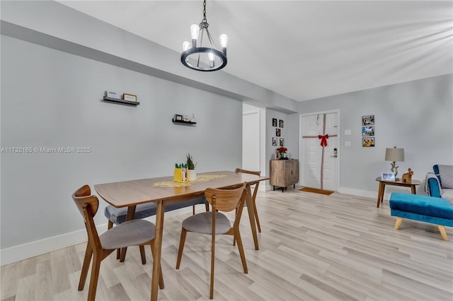 dining area with a chandelier and light hardwood / wood-style flooring