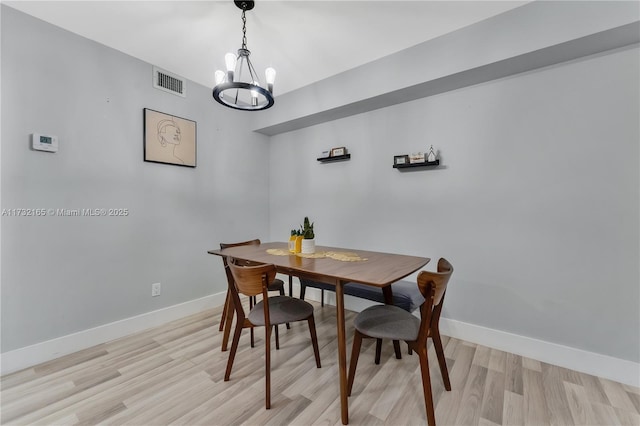 dining area with a chandelier and light hardwood / wood-style floors