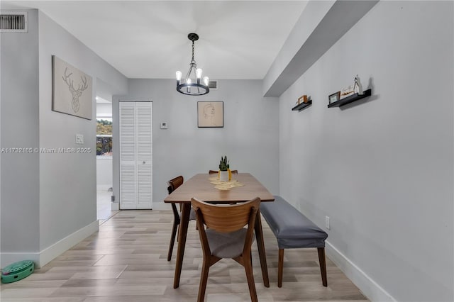 dining area featuring light hardwood / wood-style flooring and a chandelier