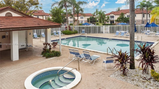 view of swimming pool with a hot tub and a patio